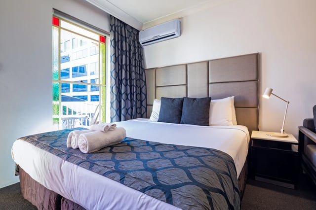 Bed with towels air conditioner lamp bedroom at ume Redfern Village in Sydney Student Accommodation