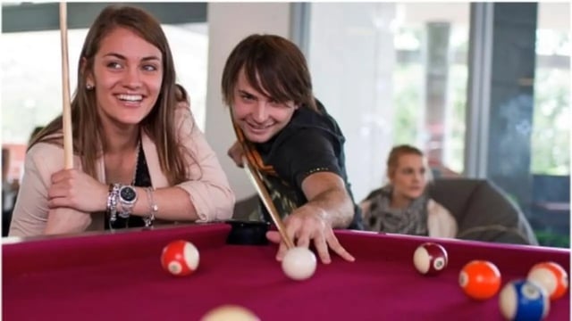 Students playing pool billiard table recreation area at Western Sydney University Campbelltown Village in Sydney Student Accommodation