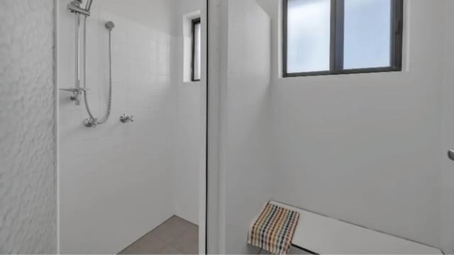 Shower stall tiled walls bench with towel bathroom at Western Sydney University Hawkesbury Village in Sydney Student Accommodation