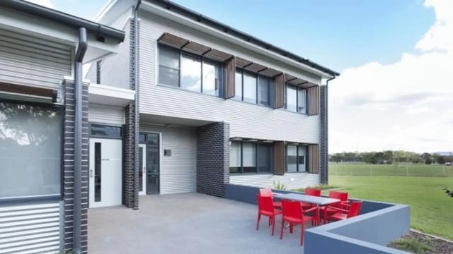 Outdoor seating area with red chairs and table exterior at Western Sydney University Hawkesbury Village in Sydney Student Accommodation