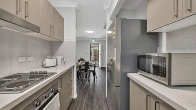 Stove toaster microwave refrigerator dining table kitchen at Western Sydney University Hawkesbury Village in Sydney Student Accommodation
