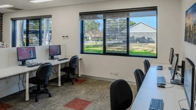 Computer workstations with monitors keyboards and chairs study area at Western Sydney University Hawkesbury Village in Sydney Student Accommodation