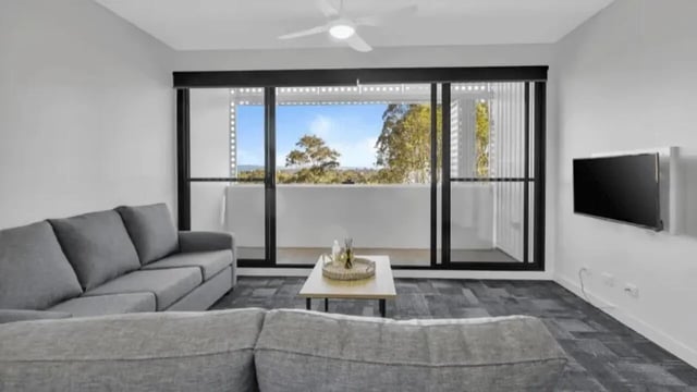 Grey sofas coffee table television living room at Western Sydney University Penrith Village in Sydney Student Accommodation