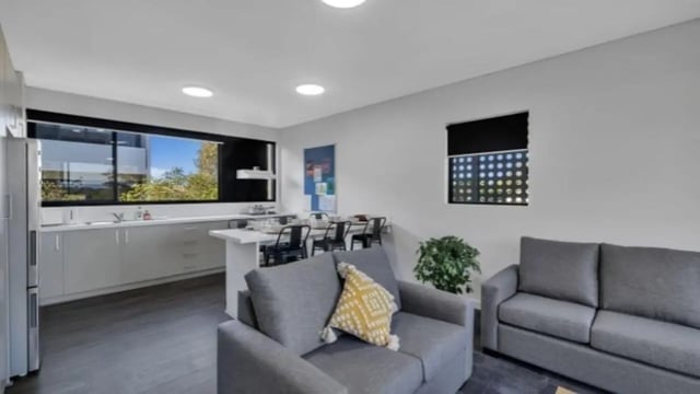 Two grey sofas and kitchen area living room at Western Sydney University Penrith Village in Sydney Student Accommodation