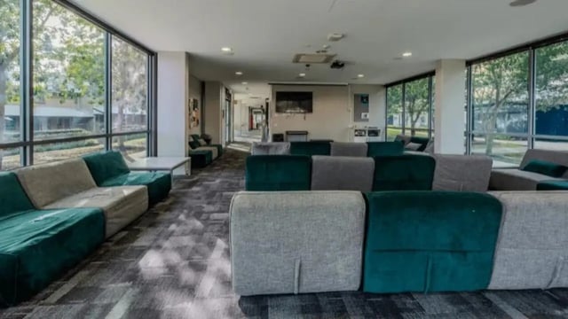 Green and grey sofas in a common area living room at Western Sydney University Penrith Village in Sydney Student Accommodation