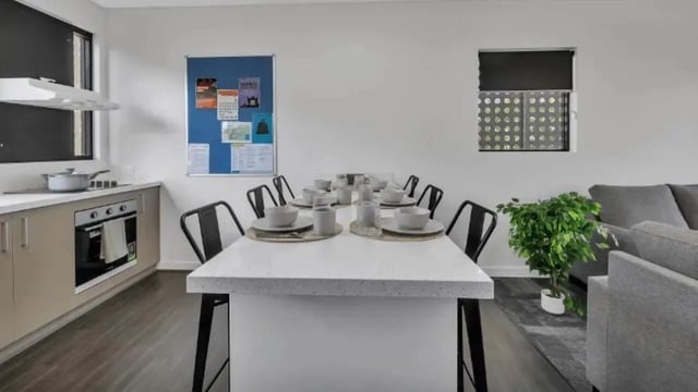 Dining table with place settings kitchen area living room exterior at Western Sydney University Penrith Village in Sydney Student Accommodation