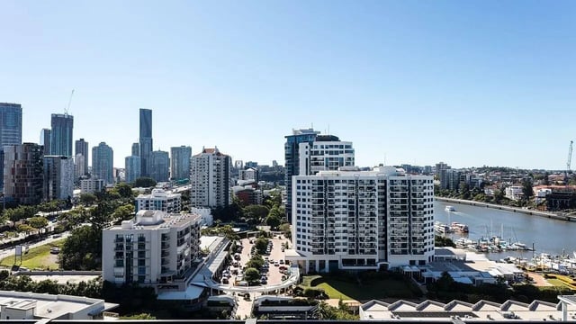 Apartment buildings on river with city skyline exterior at Realm Kangaroo Point in Brisbane Student Accommodation