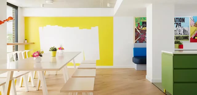 Long table benches flowers artwork colorful communal area at Scape Abercrombie in Sydney Student Accommodation