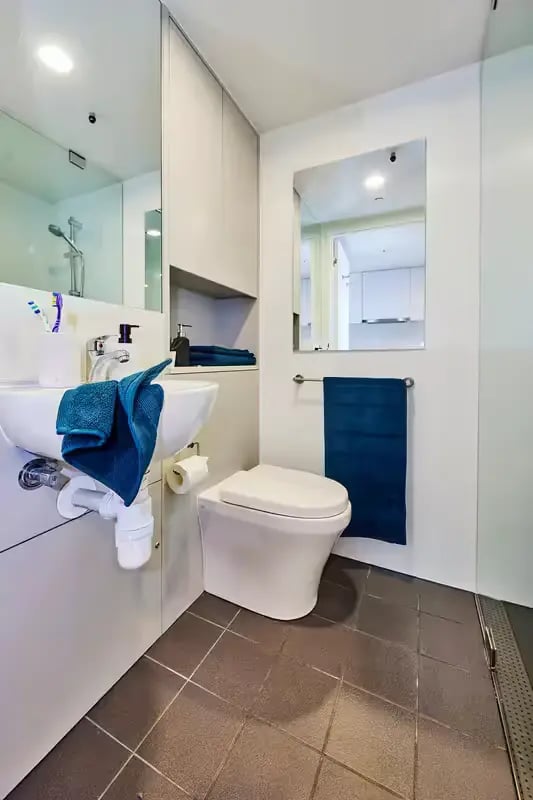Sink toilet blue towel storage cabinets bathroom at Scape at University of Sydney in Sydney Student Accommodation