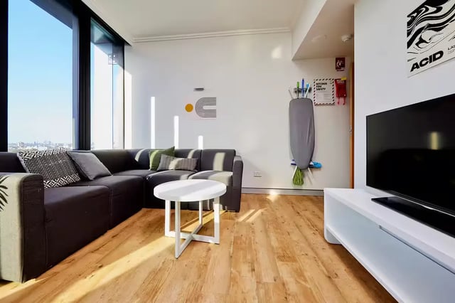 Sofa coffee table ironing board tv living room at Scape at University of Sydney in Sydney Student Accommodation