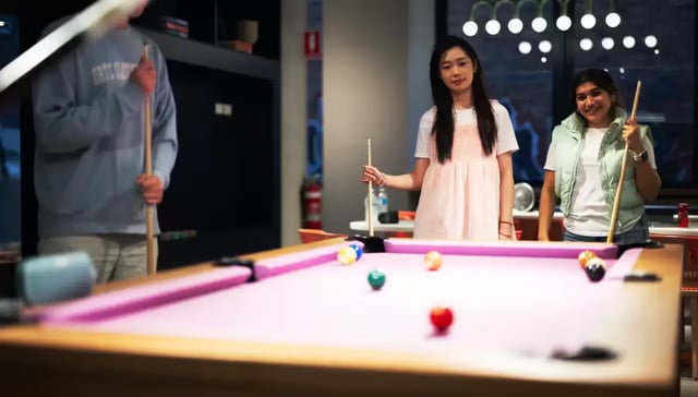Students playing billiards in a recreation area at Scape Leicester in Melbourne Student Accommodation
