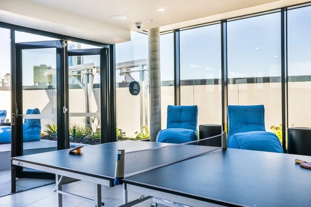 Ping pong table blue chairs large windows playing area at Scape Peel in Melbourne Student Accommodation