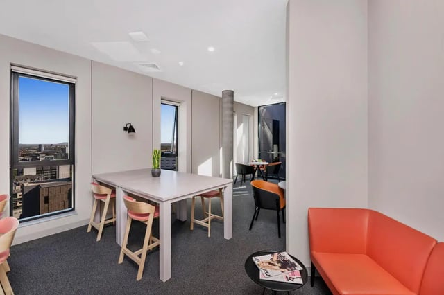 Table chairs plant couch magazines lounge area at Scape Peel in Melbourne Student Accommodation