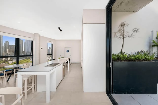 White island kitchen with cityscape view kitchen at Scape Peel in Melbourne Student Accommodation