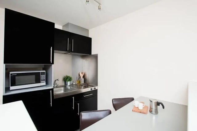 Microwave sink stove with chairs kitchen at Studio 58 in Bristol Student Accommodation