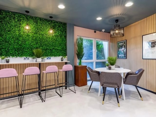 Green wall pink stools round table study area at Filbert Village in Leicester Student Accommodation