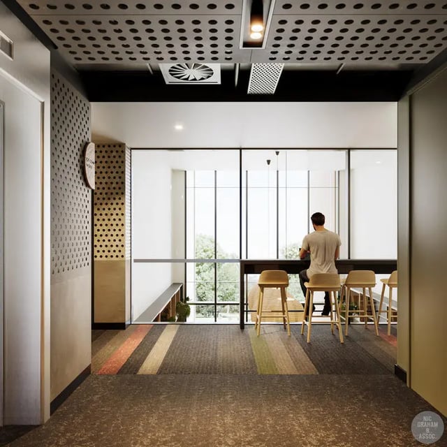 Modern lounge with student at counter and chairs at EPIISOD Macquarie Park in Sydney Student Accommodation