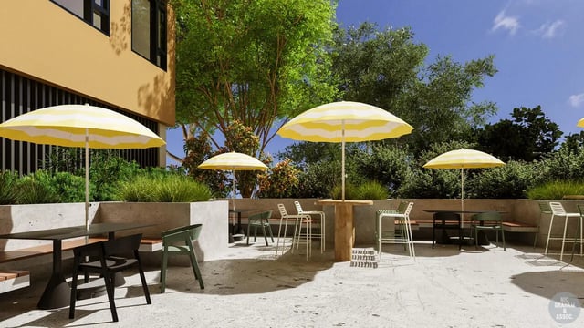 Outdoor seating with tables umbrellas and greenery exterior at EPIISOD Macquarie Park in Sydney Student Accommodation