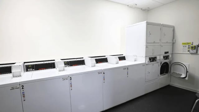 Row of white washing machines and dryers laundry room at Student Living - Shafston in Brisbane Student Accommodation