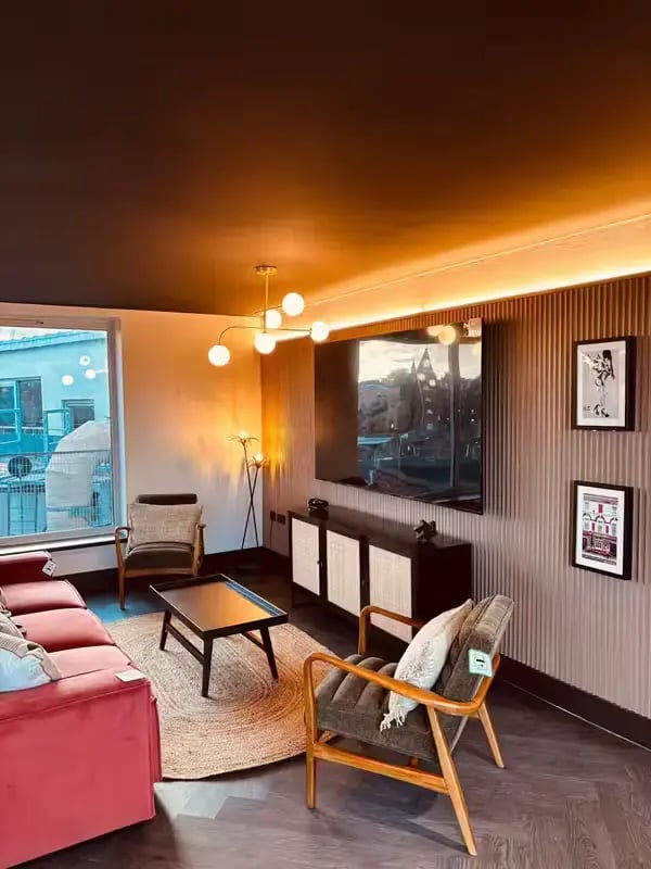 Sofa chairs rug coffee table TV media unit living room at Camden Hawley Crescent in London Student Accommodation