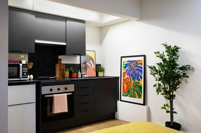 Modern black kitchen with microwave oven and art kitchen at Piccadilly Court in London Student Accommodation
