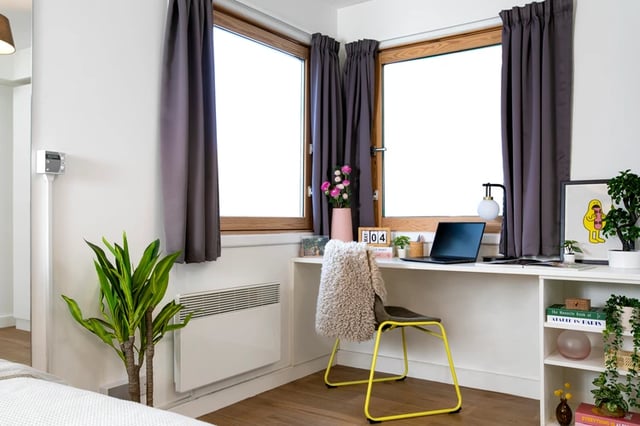 Desk with laptop, plants, and chair Study area at Piccadilly Court in London Student Accommodation