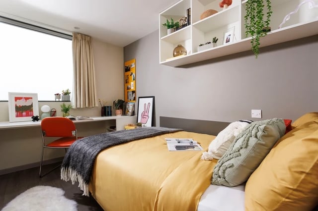 Bed desk chair shelves pillows artwork bedroom at Olympic Way in London Student Accommodation