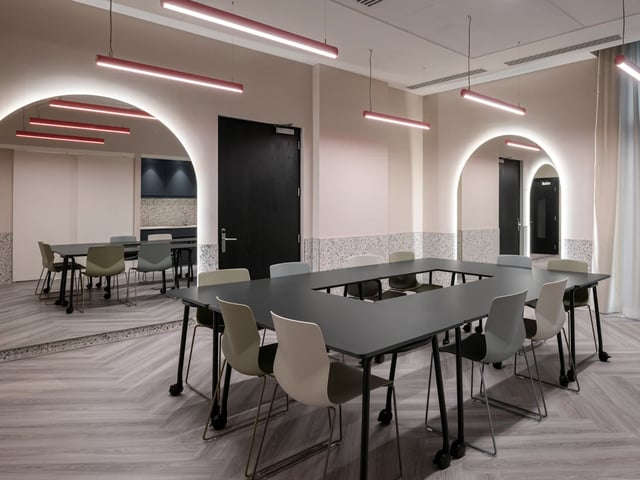 U-shaped table with chairs modern lighting meeting room at Spring Mews in London Student Accommodation