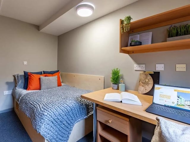 Bed desk bookshelf laptop open book bedroom at Devonshire Courtyard in Sheffield Student Accommodation