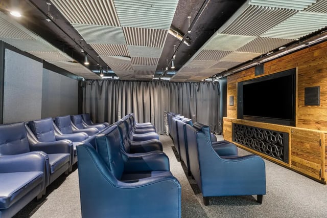 Blue leather chairs with large screen cinema room at Chapter Aldgate in London Student Accommodation
