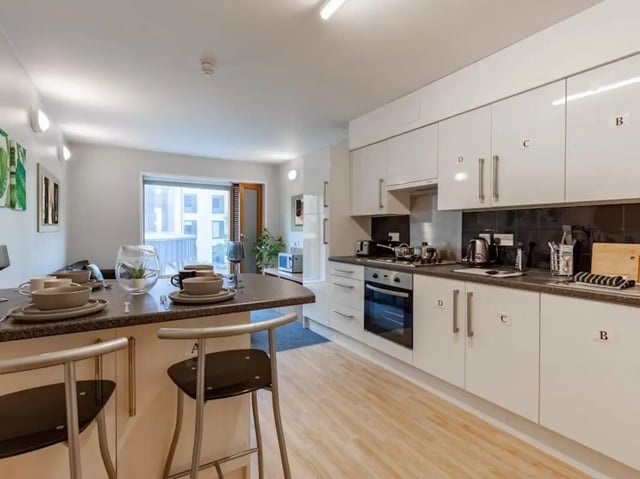Kitchen island with stools and modern white kitchen cabinets Kitchen at Kendrick Hall in Reading Student Accommodation
