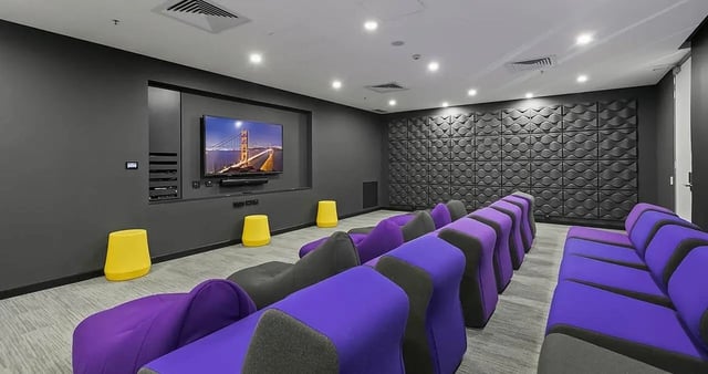 Theater seating with yellow stools media console living room at Iglu Central Park in Sydney Student Accommodation