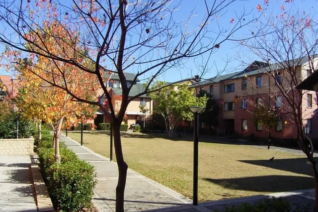 Apartment buildings with lawn and trees exterior at Sydney University Village in Sydney Student Accommodation