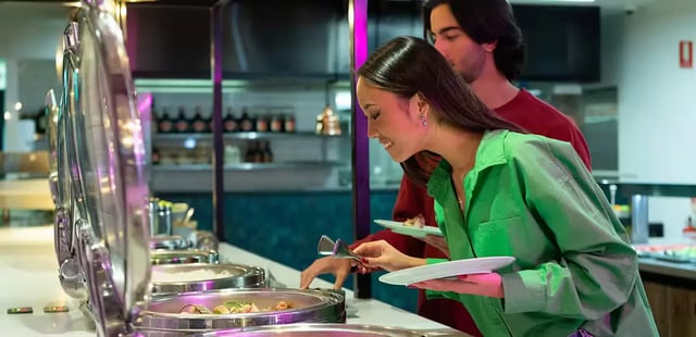 Buffet food with people serving themselves dining area at Scape Darling House in Sydney Student Accommodation
