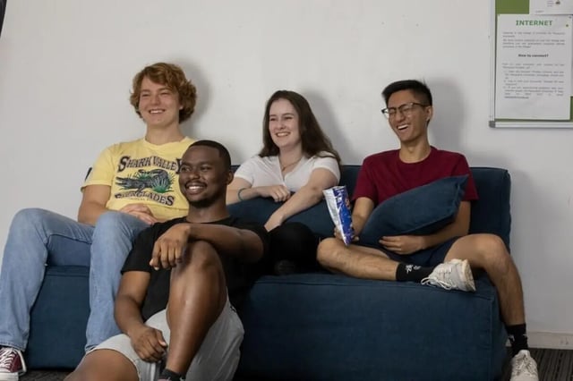 Four students relax on couch living room at Student Village North Ryde in Sydney Student Accommodation