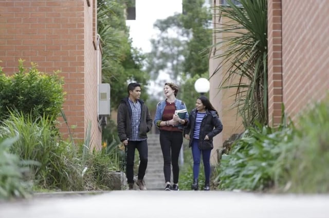 Three students walking outdoors between buildings exterior at Student Village North Ryde in Sydney Student Accommodation