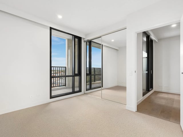 Mirrored closet doors large window unfurnished bedroom at BELONG Clayton Melbourne in Melbourne Student Accommodation
