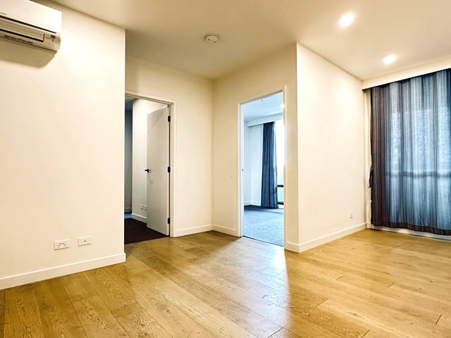 Empty room with wood floors and doors living room at BELONG Clayton Melbourne in Melbourne Student Accommodation