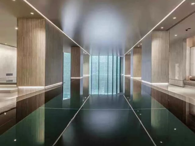 Glossy indoor swimming pool with wood paneling and glass walls. at Belong Melbourne CBD in Melbourne Student Accommodation