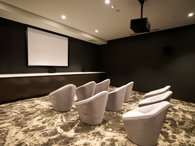 Grey chairs before projection screen cinema room at Belong Melbourne CBD in Melbourne Student Accommodation