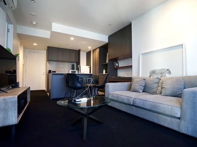 Sofa kitchen island dining table living room at Belong Melbourne CBD in Melbourne Student Accommodation