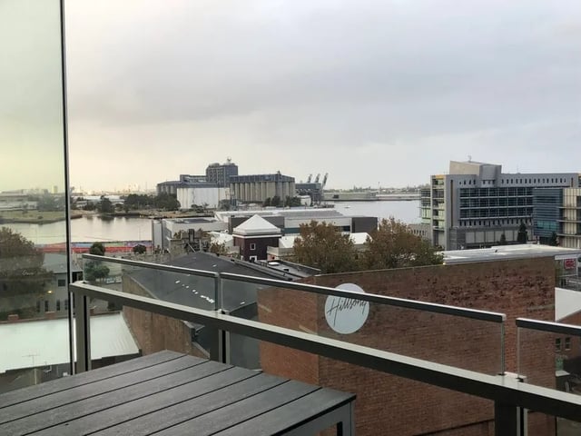 Balcony table and city waterfront view exterior at BELONG Newcastle NSW in Newcastle Student Accommodation