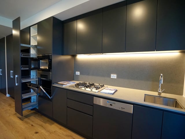 Modern dark grey kitchen cabinets with integrated appliances kitchen at BELONG Newcastle NSW in Newcastle Student Accommodation