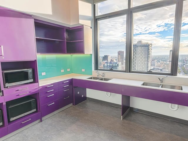 Purple cabinets microwaves dual sinks kitchen at Yugo Adelaide City in Adelaide Student Accommodation