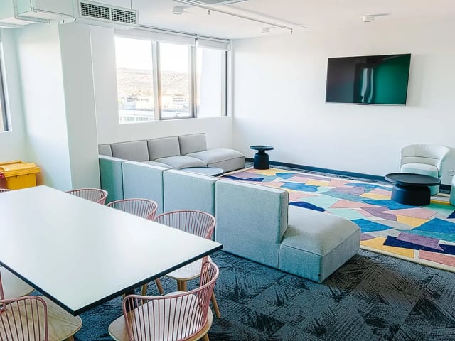 Lounge area with sofa dining table television living room at Yugo Adelaide City in Adelaide Student Accommodation