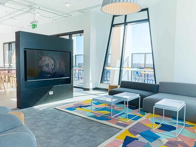 Modern lounge with grey sofas and colorful rug living room at Yugo Adelaide City in Adelaide Student Accommodation