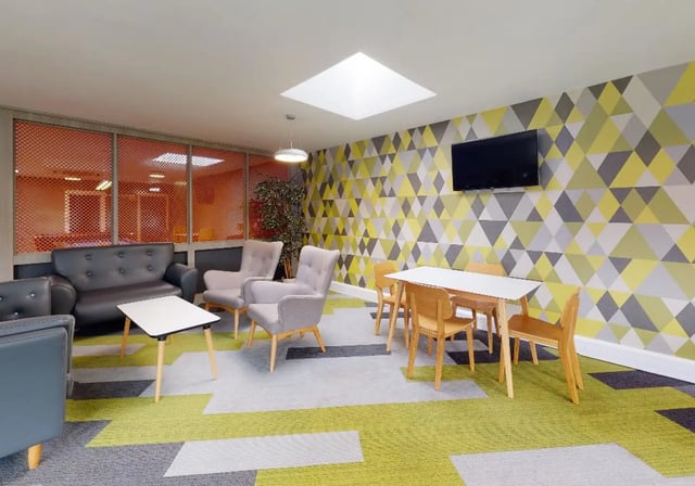 Sofas chairs table TV geometric wallpaper common area at iQ Newtown House in Nottingham Student Accommodation
