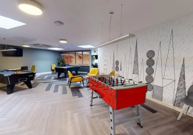 Pool tables foosball table yellow chairs playing area at iQ Newtown House in Nottingham Student Accommodation