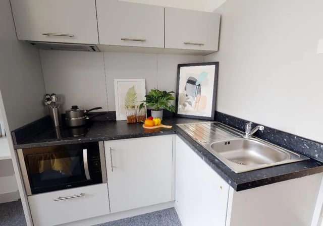 Microwave sink pots artwork and cabinets kitchen at iQ Newtown House in Nottingham Student Accommodation