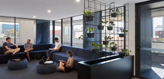 People relaxing on sofa and floor in lounge area at Scape Waymouth in Adelaide Student Accommodation